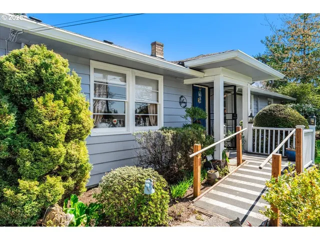 a view of a house with wooden fence next to a yard
