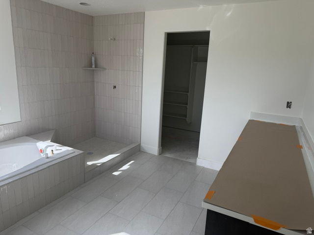 1931 South Fitzroy Road Ogden, UT 84401 - Photo 8 of 12 Subway tile shower with integrated shelving, built-in soaking tub, tile flooring, and a countertop vanity space
