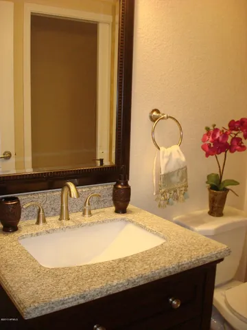 a bathroom with a granite countertop sink and a bathtub