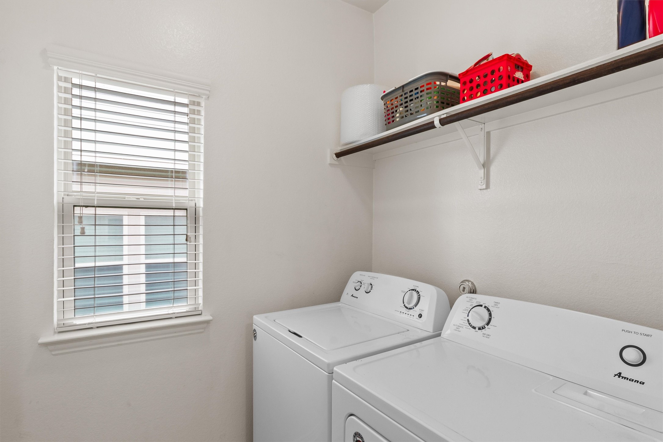 10413 Crescendo Lane Austin, TX 78747 - Photo 22 of 32 Functional laundry space with a window for natural illumination and convenient shelving.