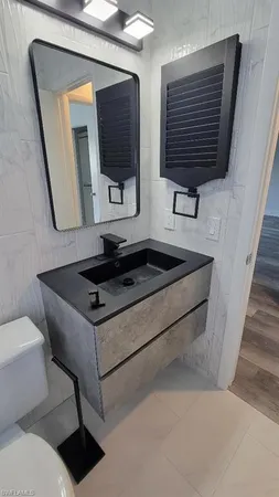 a bathroom with a sink a toilet and mirror