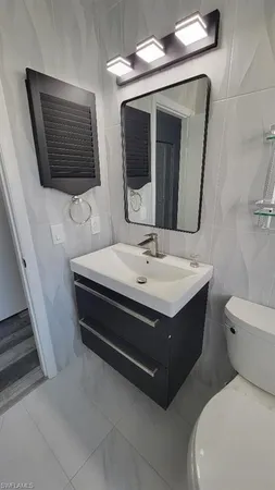 a bathroom with a sink a toilet and a shower