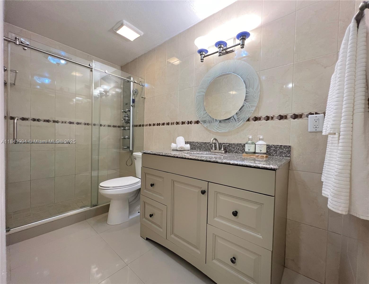 636 Northwest 11th Street, Unit 636 Miami, FL 33136 - Photo 11 of 17 a bathroom with a granite countertop sink mirror toilet and shower