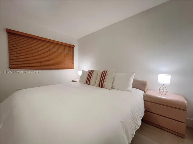 a bedroom with a bed and a night stand