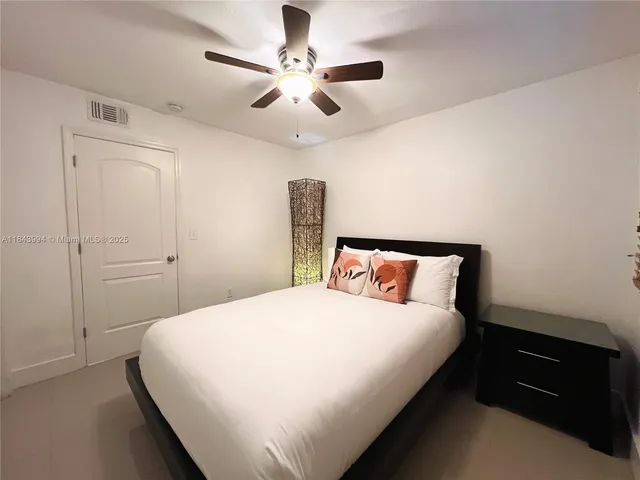 a bedroom with a large bed and a ceiling fan