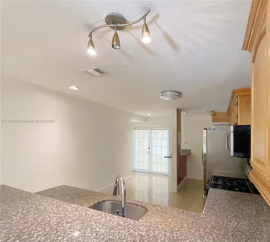 a view of a livingroom with a dinning area hardwood floor and a ceiling fan
