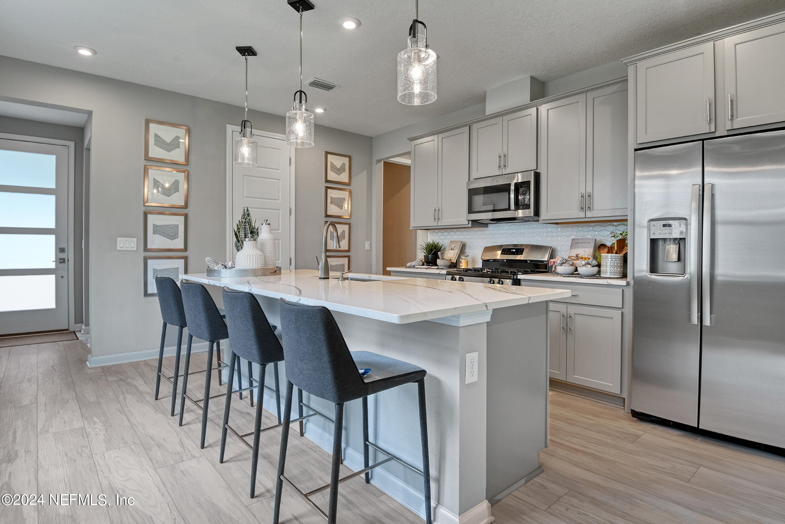 7213 Red Timber Road Jacksonville, FL 32244 - Photo 8 of 17 a kitchen with stainless steel appliances granite countertop a refrigerator a stove a sink a dining table and chairs with wooden floor