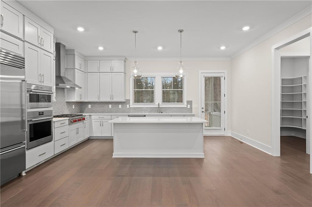 320 Anglin Walk Alpharetta, GA 30009 - Photo 12 of 67 a large kitchen with stainless steel appliances kitchen island granite countertop a stove and a sink