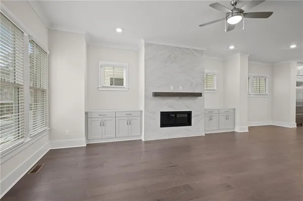 a view of an empty room with window and wooden floor