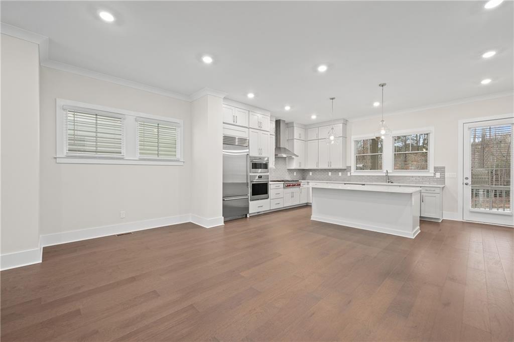 320 Anglin Walk Alpharetta, GA 30009 - Photo 10 of 67 a large white kitchen with kitchen island a sink a stove and a refrigerator