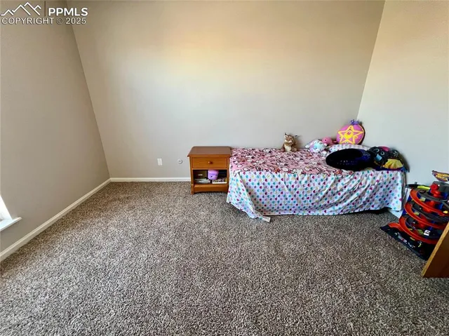 a view of a room that has a bed and a dresser in it