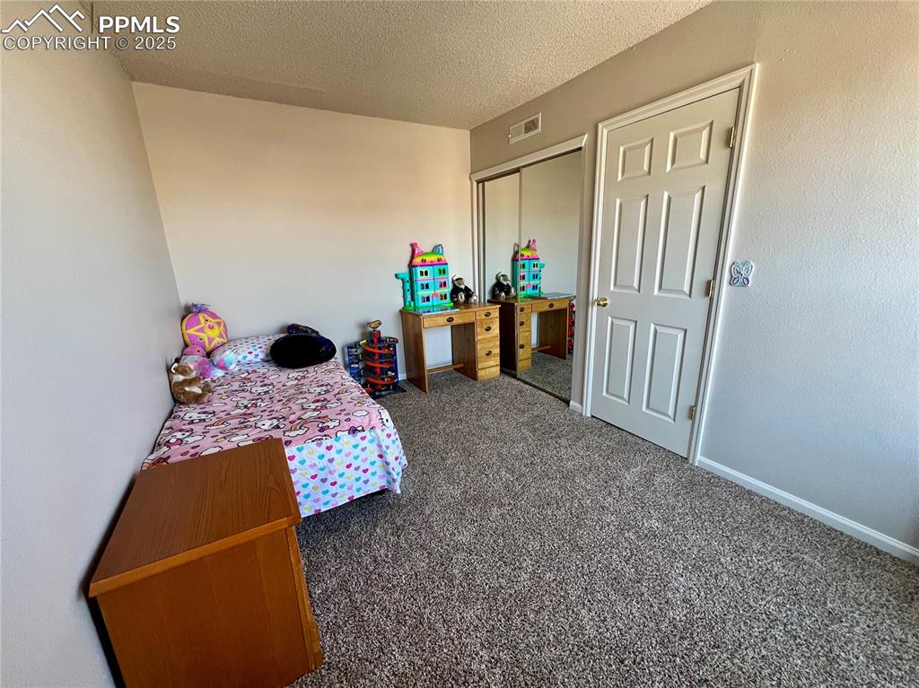 3150 Van Teylingen Drive, Unit E Colorado Springs, CO 80917 - Photo 17 of 24 a bedroom with a bed and a window