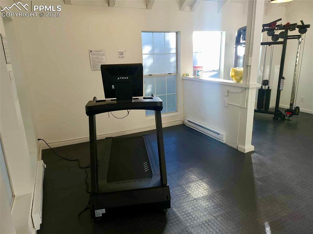 3150 Van Teylingen Drive, Unit E Colorado Springs, CO 80917 - Photo 24 of 24 a living room with a table chairs and a flat screen tv