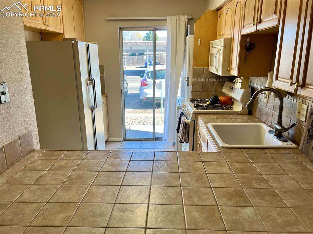 3150 Van Teylingen Drive, Unit E Colorado Springs, CO 80917 - Photo 7 of 24 a view of a kitchen with fridge and windows