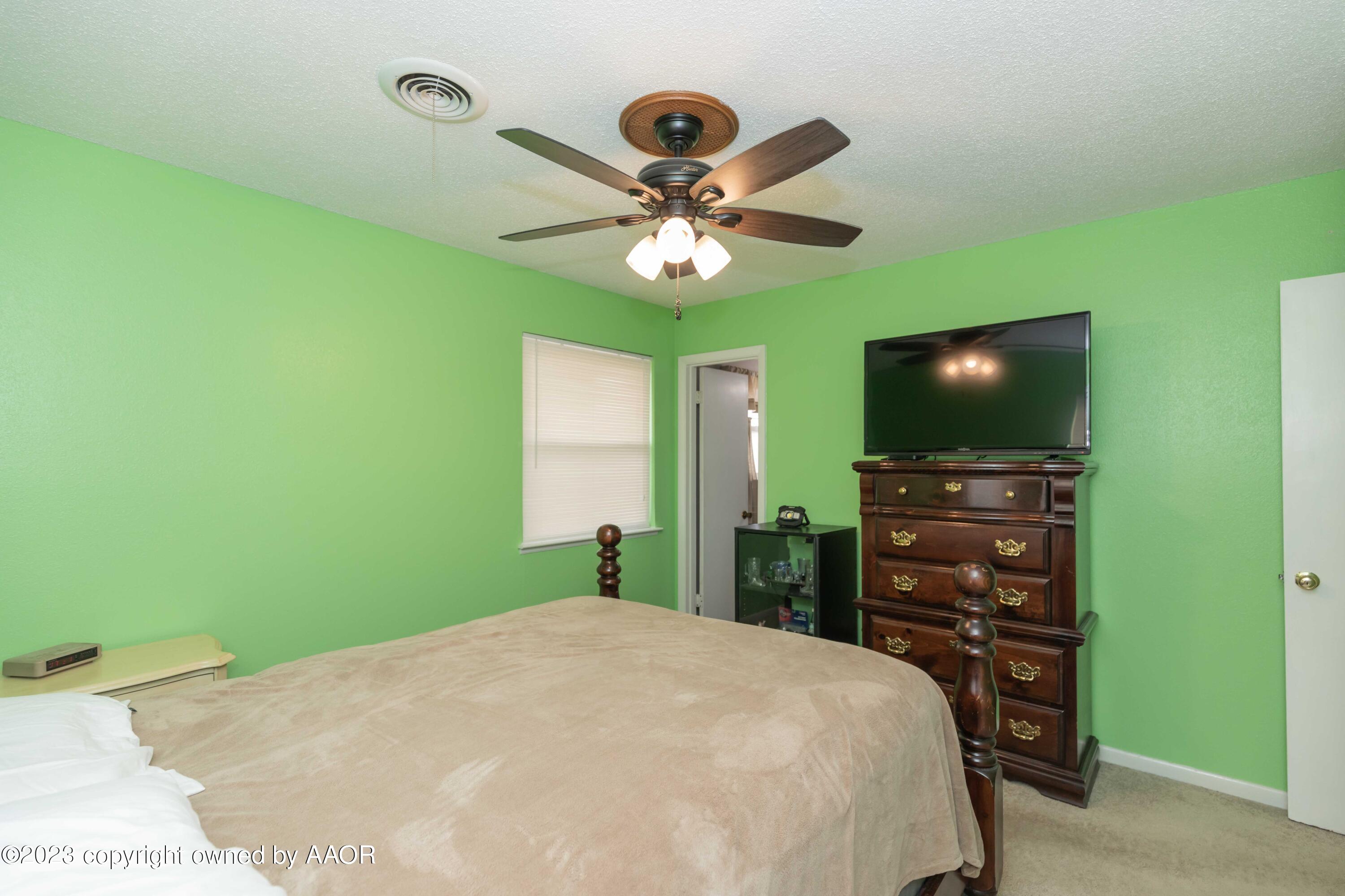 2920 South Nelson Street Amarillo, TX 79103 - Photo 18 of 47 a bedroom with a bed and a flat screen tv