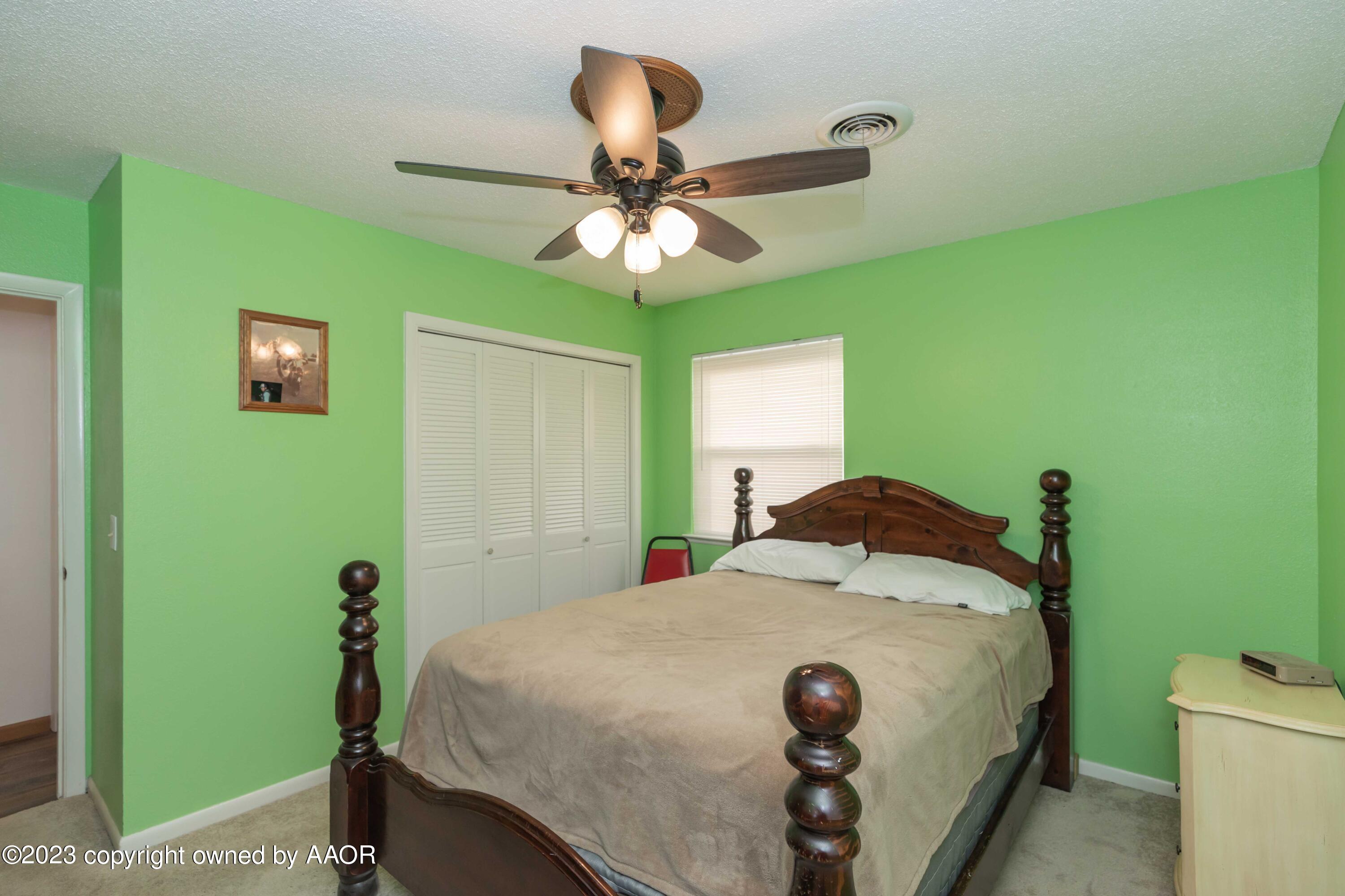 2920 South Nelson Street Amarillo, TX 79103 - Photo 19 of 47 a bed room with a bed and a chandelier
