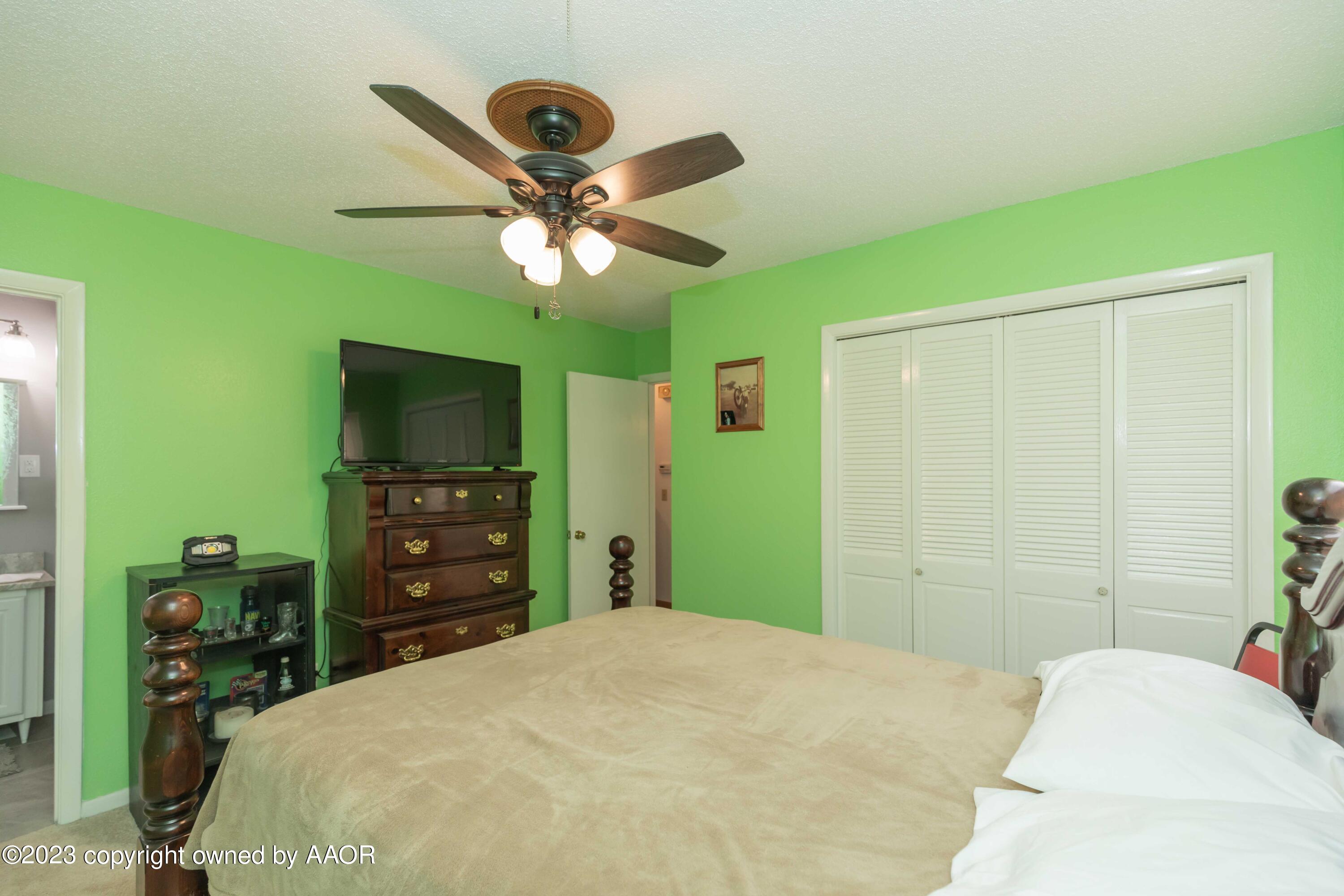 2920 South Nelson Street Amarillo, TX 79103 - Photo 20 of 47 a bedroom with a bed and a flat tv screen on dresser