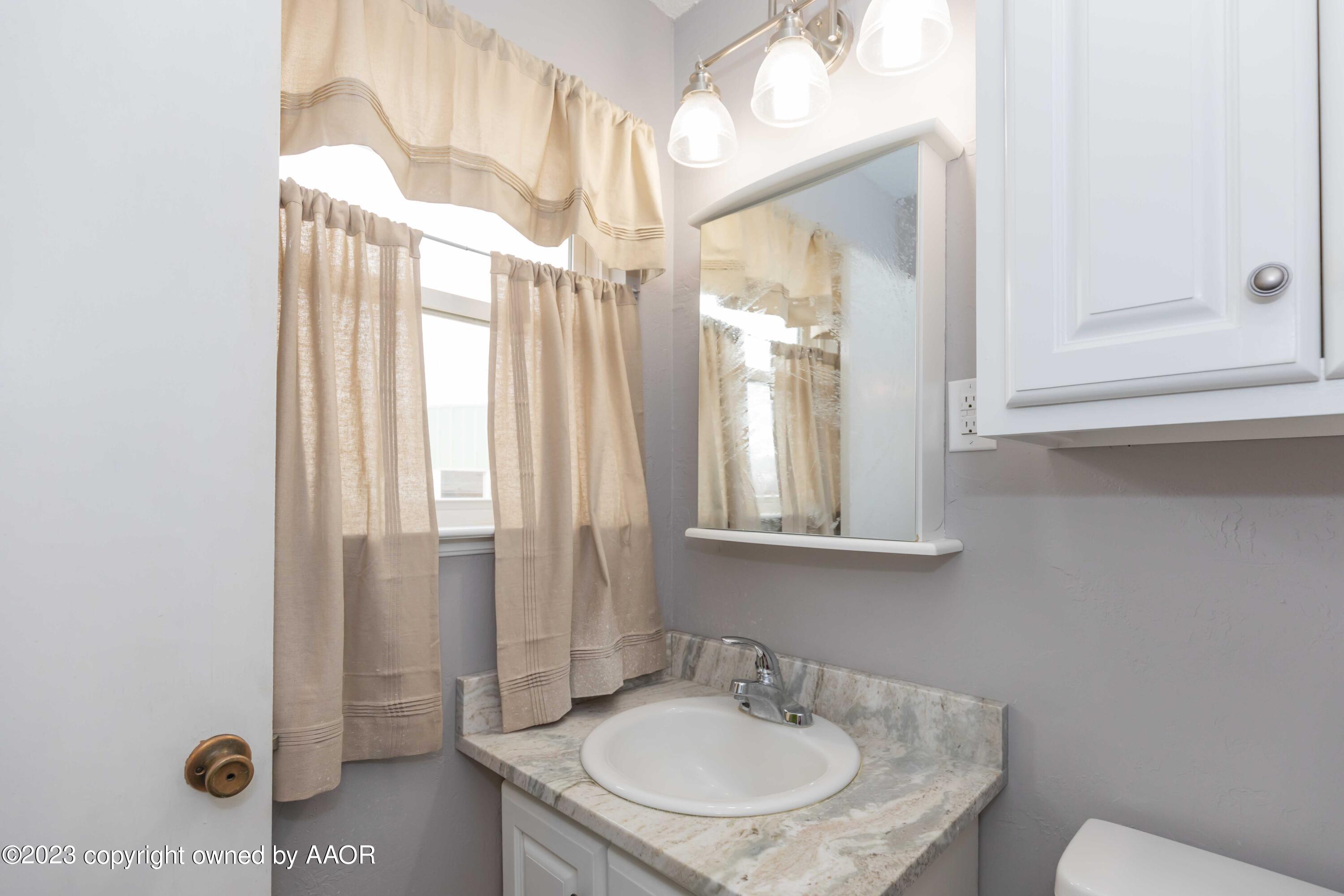 2920 South Nelson Street Amarillo, TX 79103 - Photo 22 of 47 a bathroom with a sink and a mirror