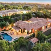 an aerial view of residential houses with outdoor space and parking