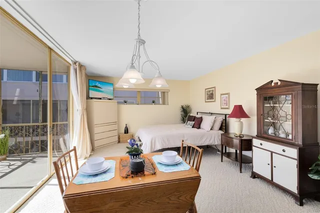 a view of a dining room with furniture a chandelier and wooden floor