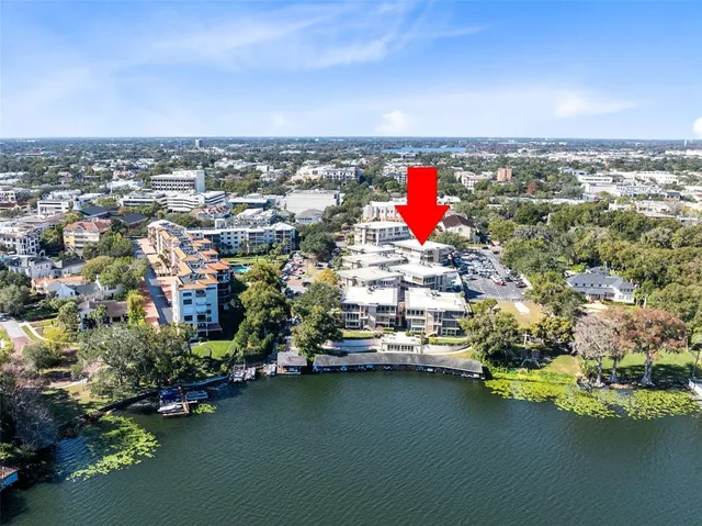 an aerial view of residential houses with outdoor space and lake view