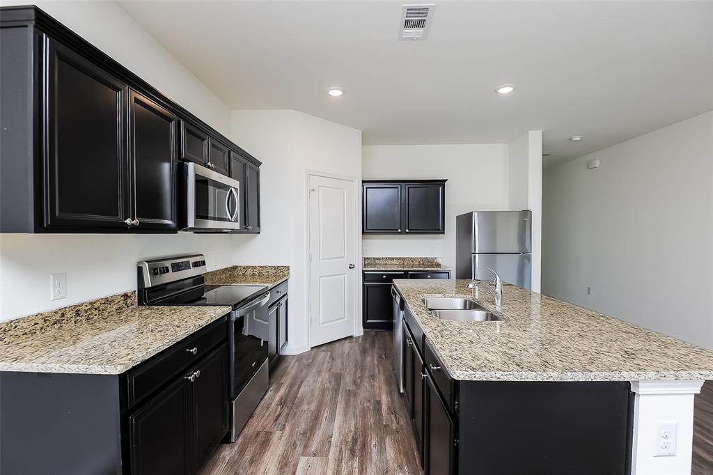 505 Canoe Way Crowley, TX 76036 - Photo 6 of 17 a kitchen with granite countertop counter space a sink appliances and cabinets