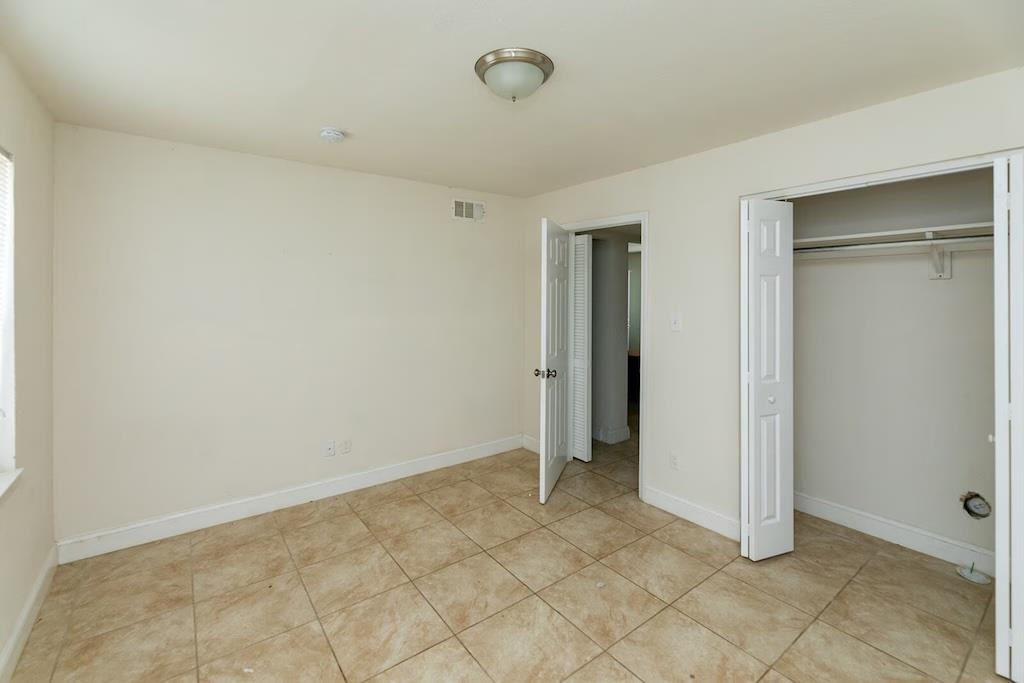 3236 Millington Road Memphis, TN 38127 - Photo 9 of 31 Room featuring light-toned square floor tiles, a window with blinds, a bi-fold closet with hanging rod, and a ceiling-mounted light fixture