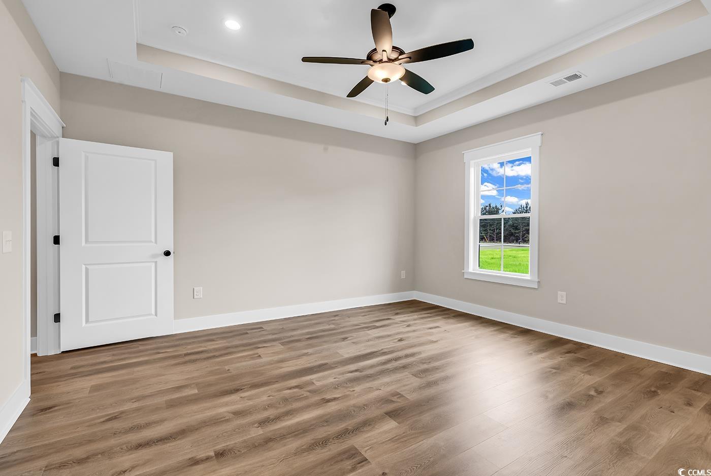 713 Horry Road Aynor, SC 29511 - Photo 18 of 40 Empty room with a tray ceiling, light wood-style floors, ceiling fan, and recessed lighting