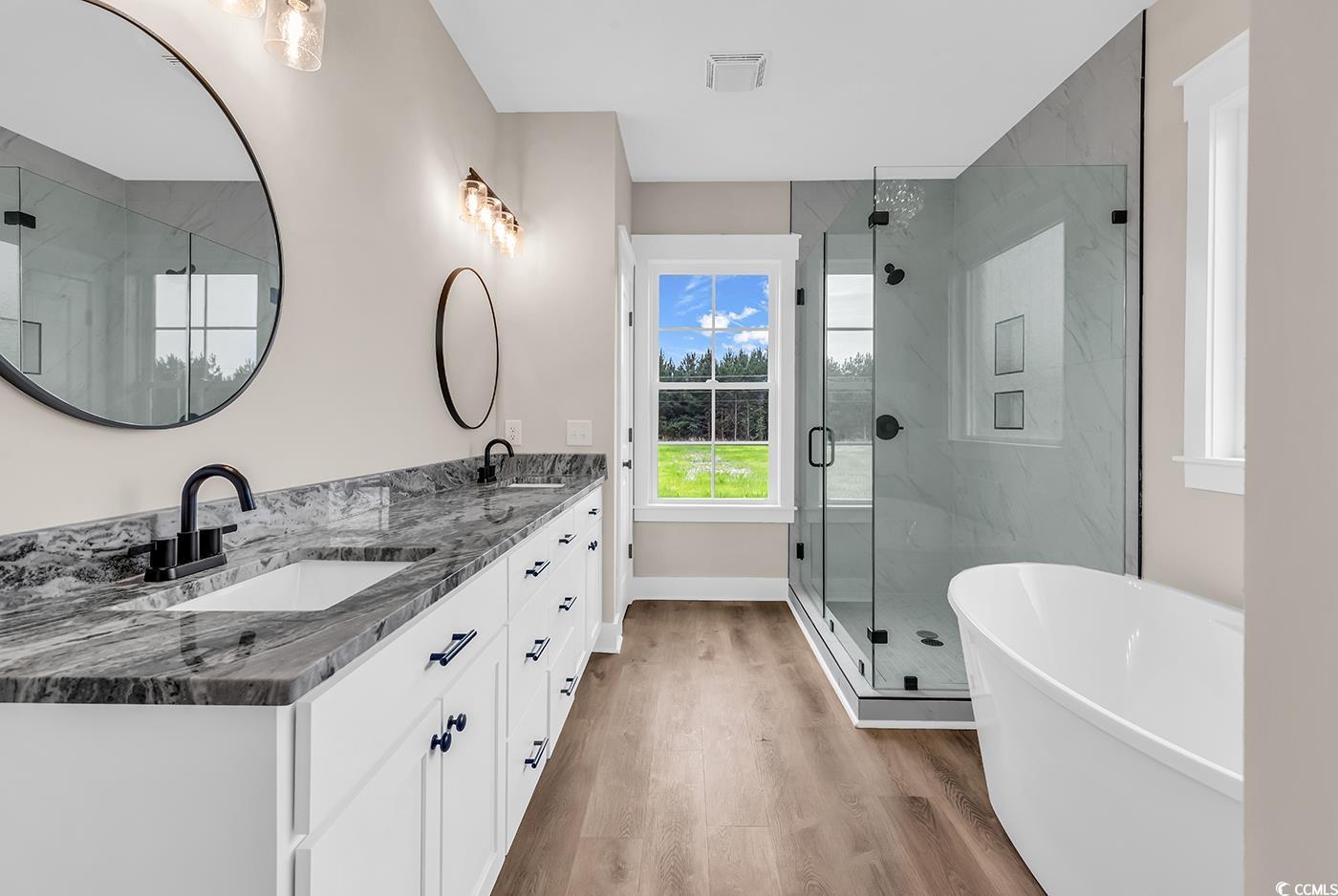 713 Horry Road Aynor, SC 29511 - Photo 19 of 40 Full bath with a freestanding tub, double vanity, a marble finish shower, and light wood finished floors