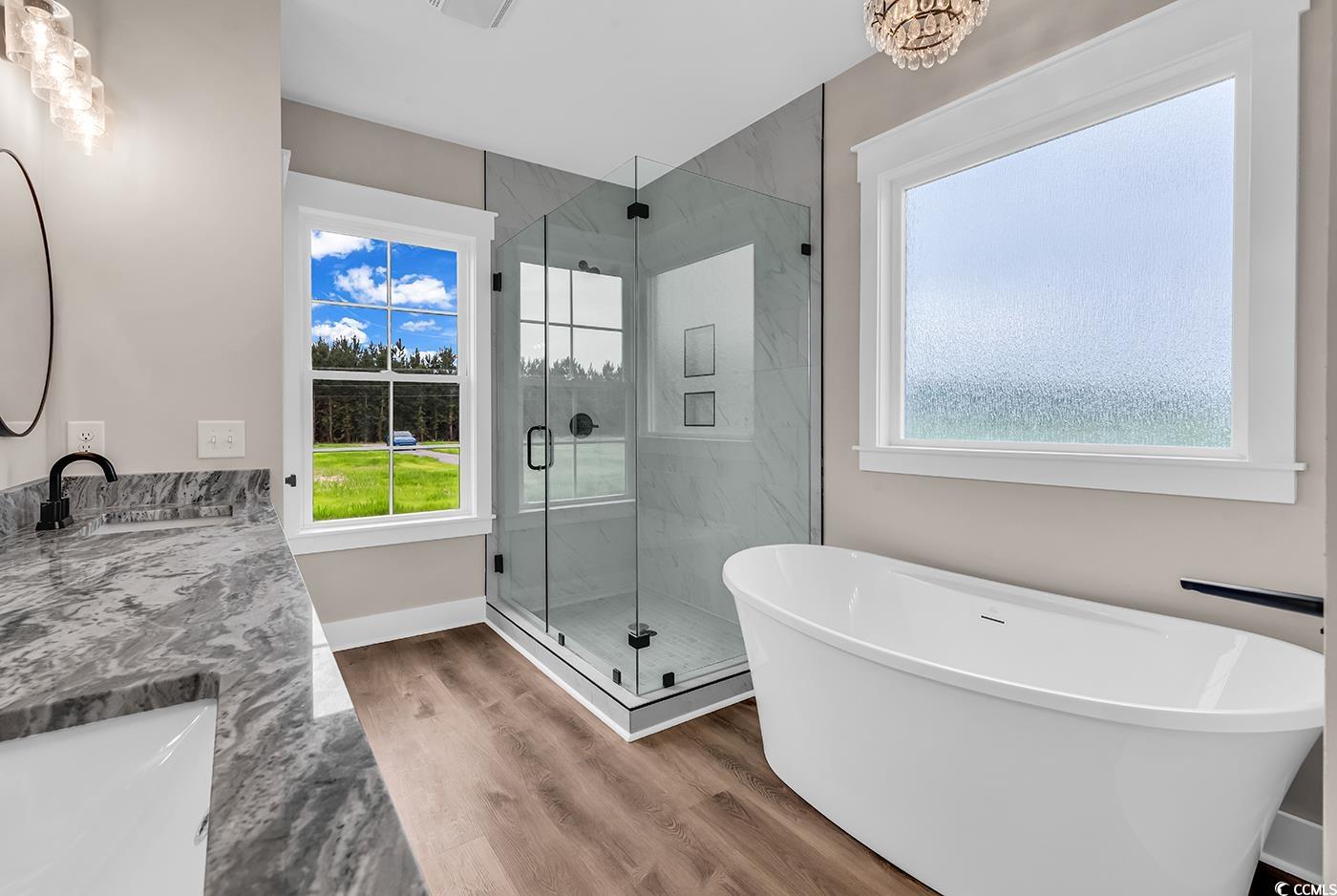 713 Horry Road Aynor, SC 29511 - Photo 20 of 40 Full bathroom with a freestanding tub, a marble finish shower, double vanity, and light wood-type flooring