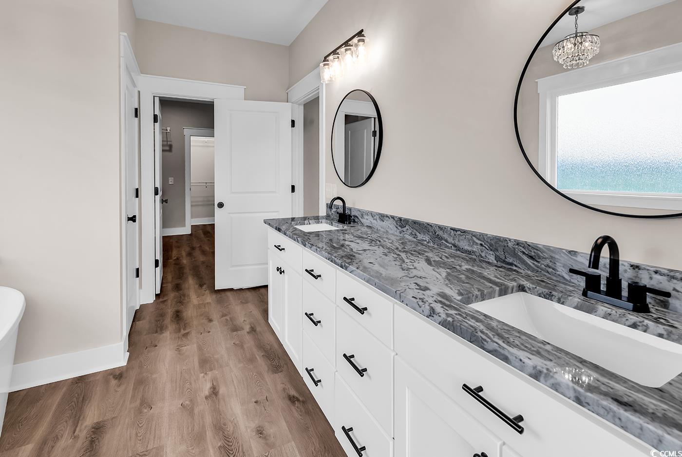 713 Horry Road Aynor, SC 29511 - Photo 21 of 40 Bathroom with double vanity, dark wood-style flooring, and a freestanding bath