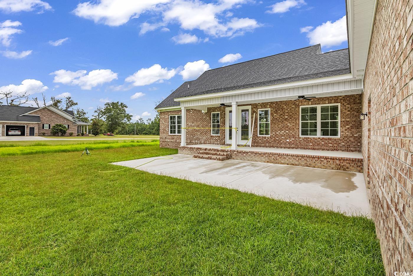 713 Horry Road Aynor, SC 29511 - Photo 35 of 40 Back of house featuring ceiling fan, a shingled roof, a lawn, brick siding, and french doors