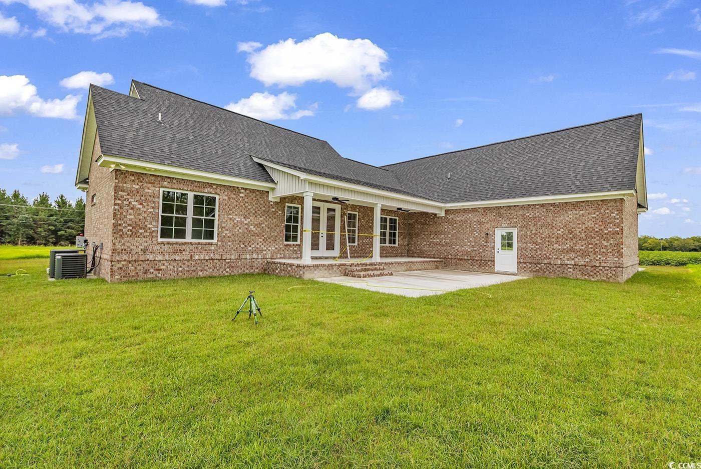 713 Horry Road Aynor, SC 29511 - Photo 37 of 40 Back of house featuring ceiling fan, a patio, roof with shingles, brick siding, and a lawn