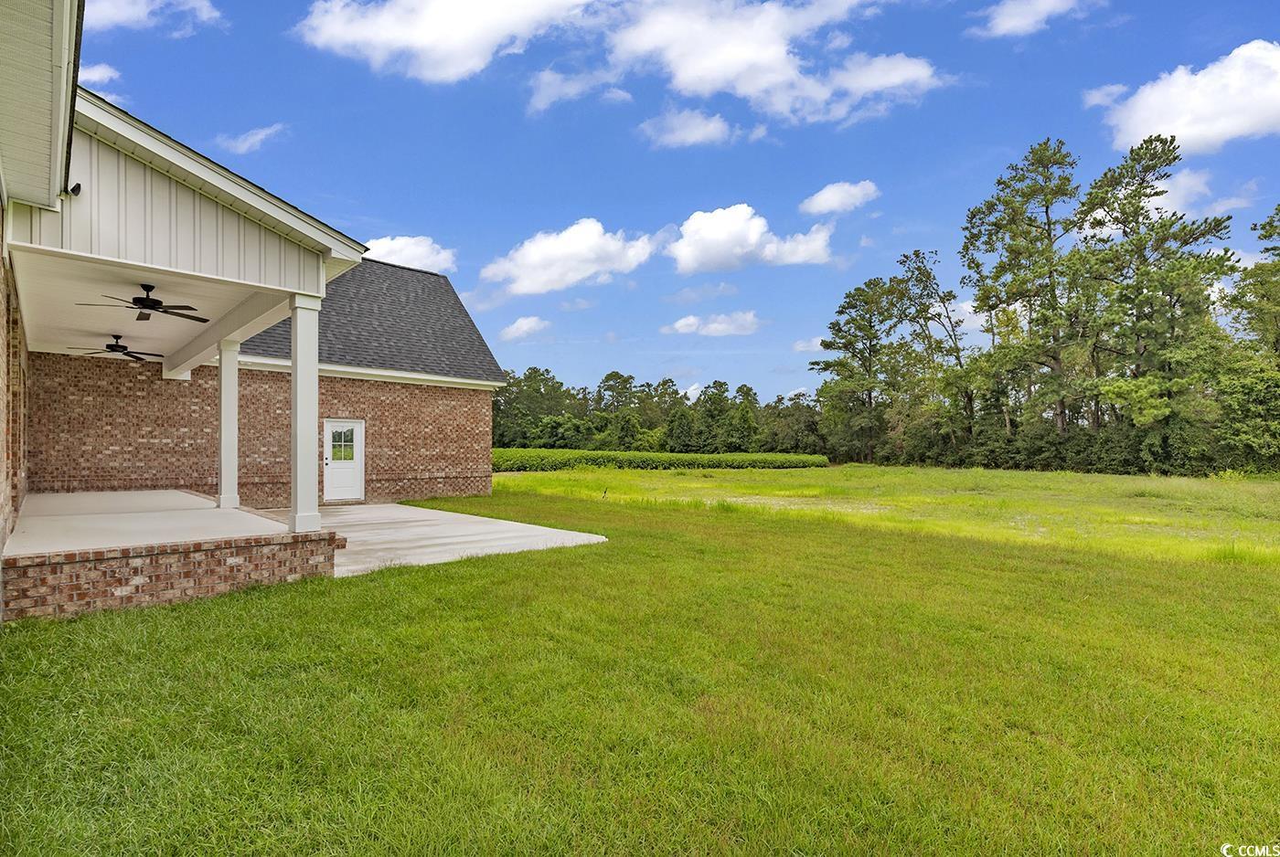 713 Horry Road Aynor, SC 29511 - Photo 38 of 40 View of green lawn featuring a ceiling fan and a patio area
