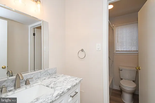 a bathroom with a granite countertop sink toilet and shower