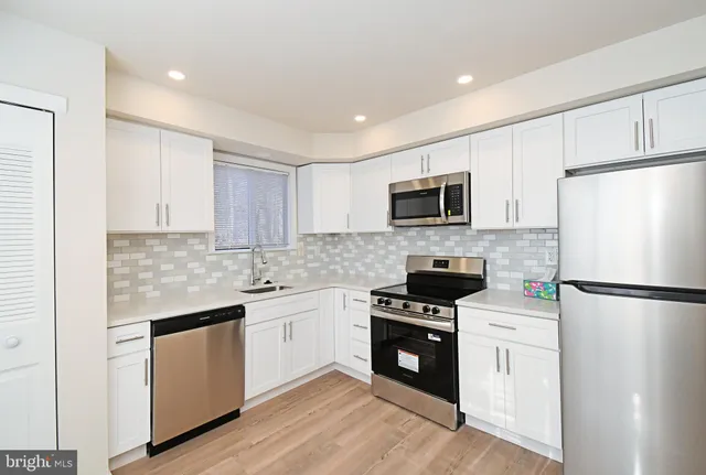 a kitchen with a sink a microwave a refrigerator and cabinets