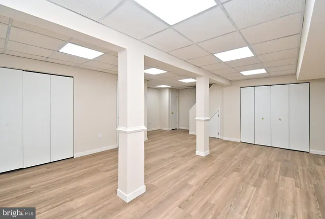 a view of an empty room with wooden floor and cabinet