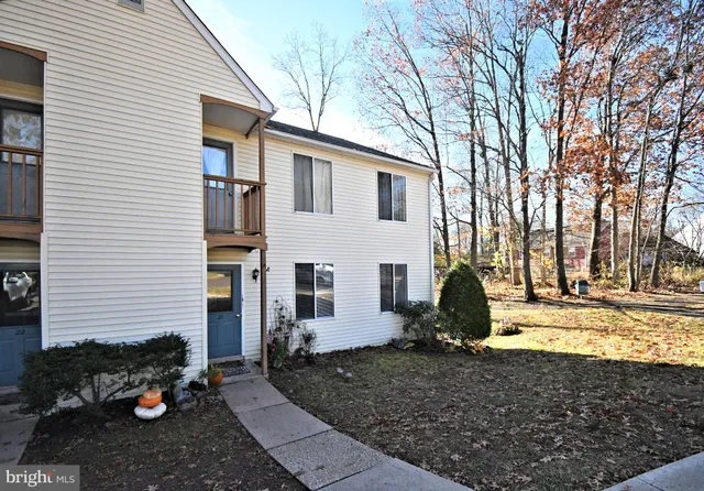 a view of a white house with a yard and large tree