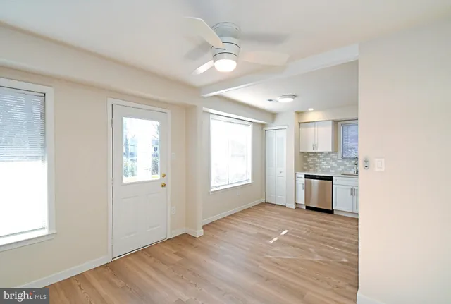 a view of empty room with kitchen and window