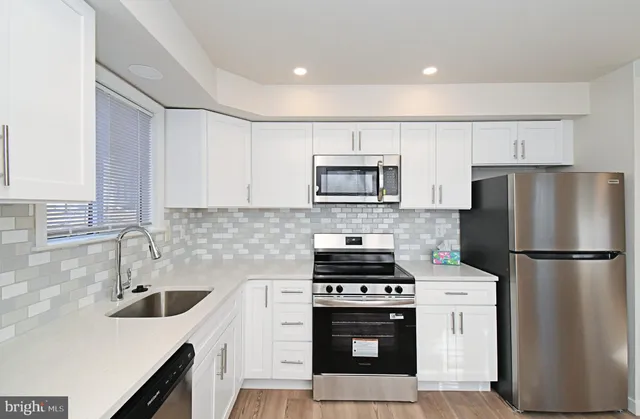 a kitchen with a refrigerator sink and stove top oven