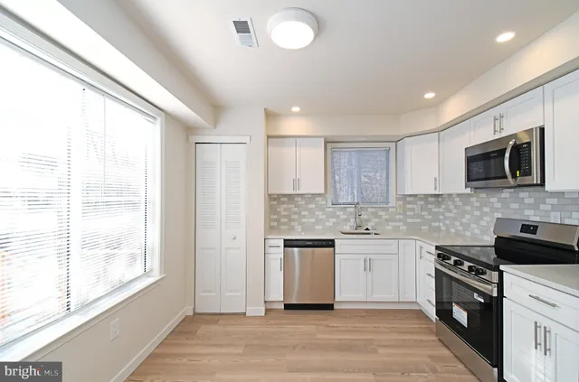 a kitchen with stainless steel appliances granite countertop a stove and a sink