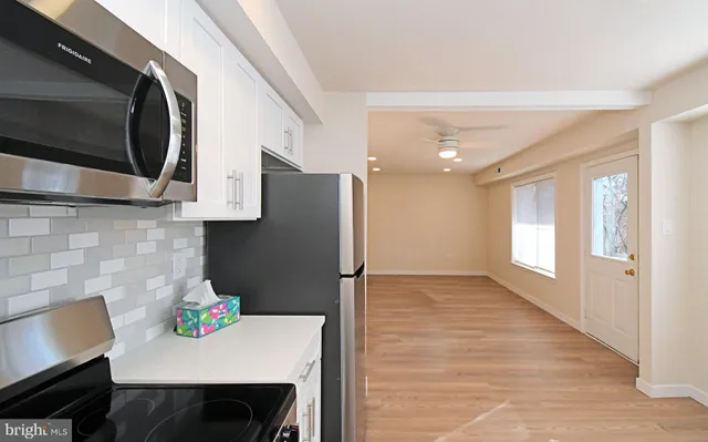 a kitchen with stainless steel appliances a microwave a sink and cabinets