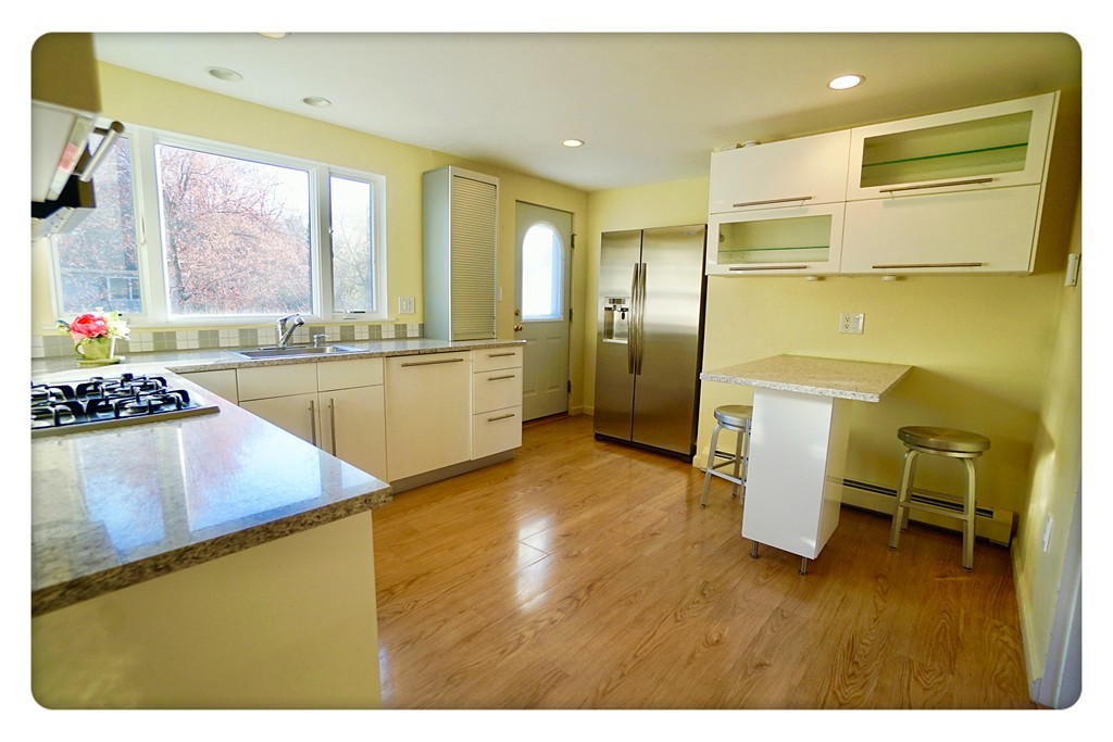 16 Hickory Street Lexington, MA 02421 - Photo 8 of 21 a kitchen with stainless steel appliances granite countertop a sink refrigerator stove and table
