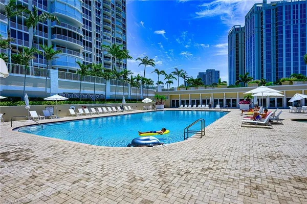a view of a swimming pool with a patio and a yard