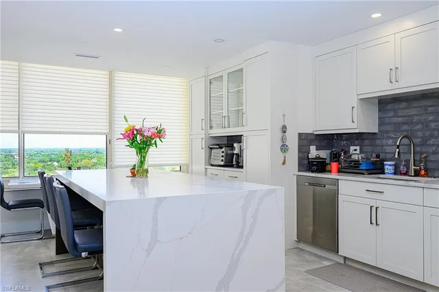 a kitchen with granite countertop white cabinets and white appliances
