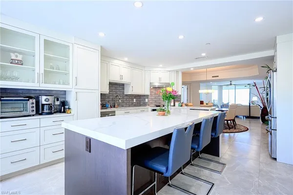 a large kitchen with kitchen island a sink a stove a refrigerator and cabinets