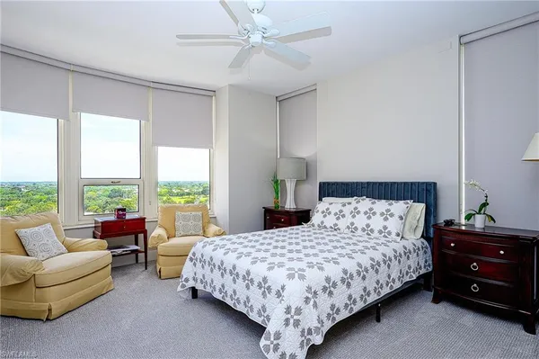 a bedroom with a bed and a couch next to a window