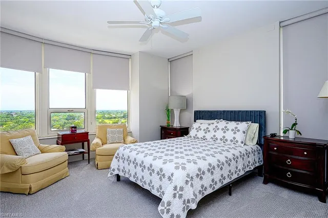 a bedroom with a bed and a couch next to a window