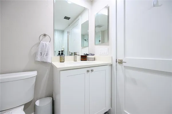 a bathroom with a sink vanity mirror and toilet