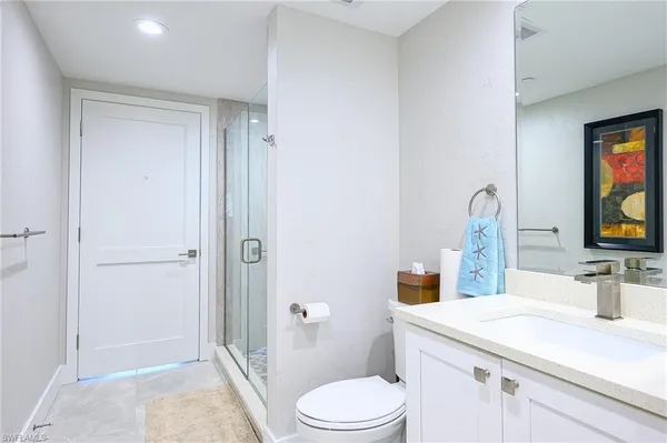 a bathroom with a sink a toilet and shower